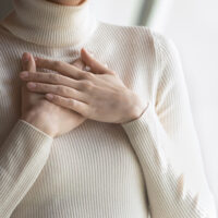 Woman feeling thankful with overlapped hands over her heart